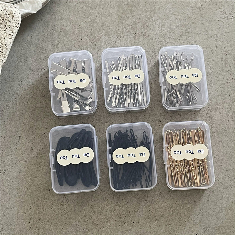 Six small plastic containers with hair accessories on a concrete surface